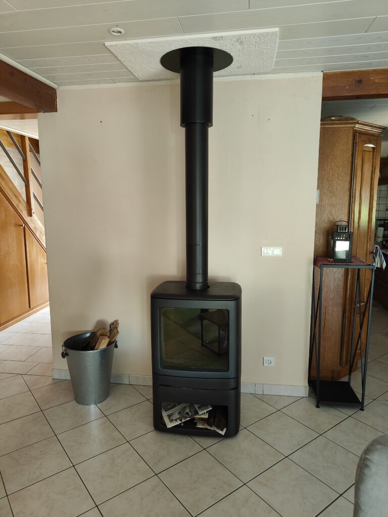 Poêle à bois éteint noir avec réserve de bois intégrée