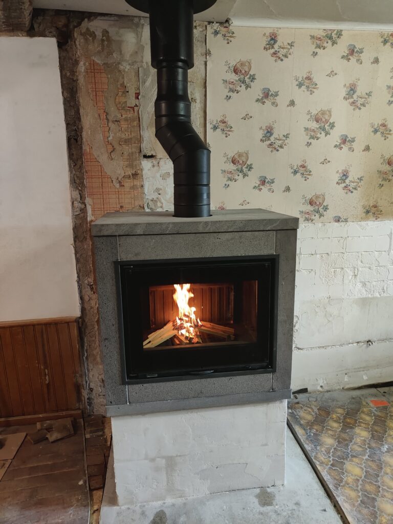Cheminée en deux partie socle blanc et insert habillage ollaire gris claire fumisterie apparente
