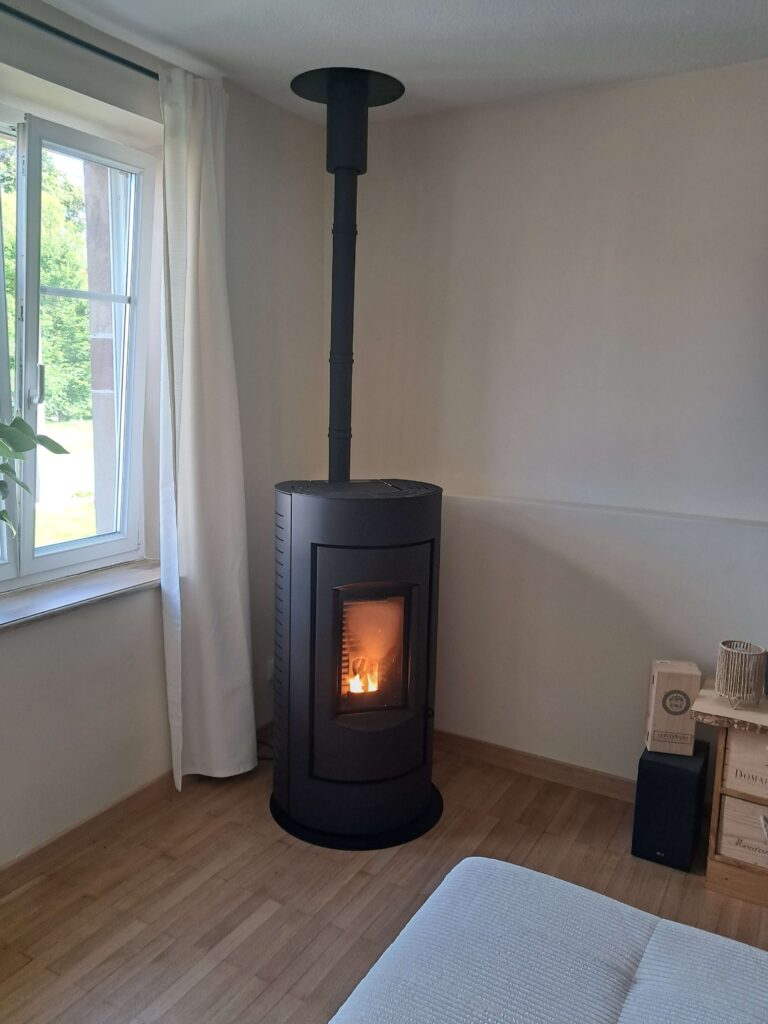 poêle à granulés installé dans un salon moderne avec foyer vitré en fonctionnement