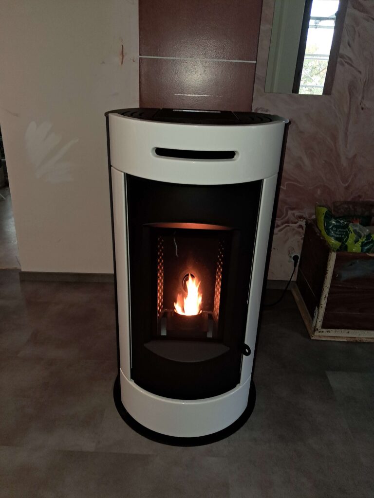 Poêle à granulés en fonctionnement avec flammes visibles derrière la vitre.
